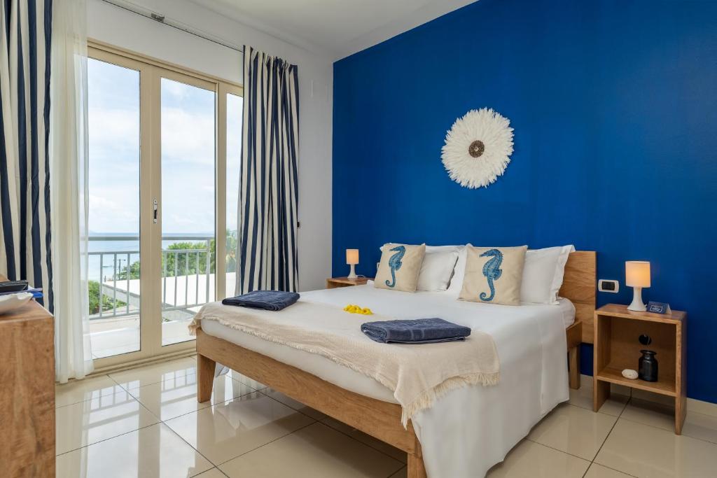 博瓦隆罗西亚别墅的蓝色的卧室设有床和大窗户