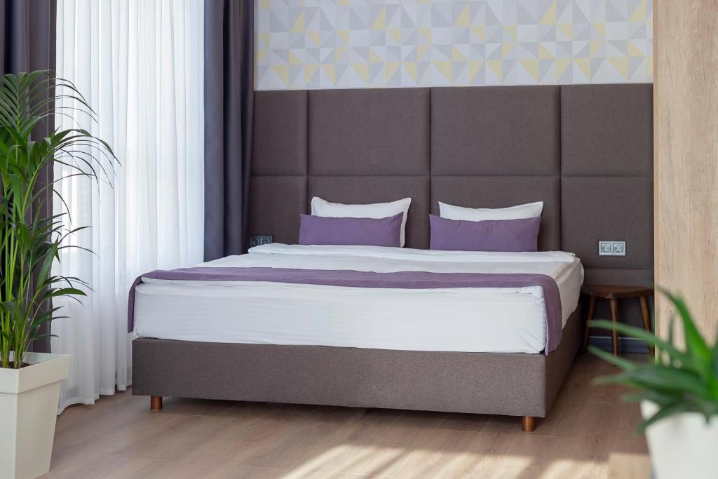 克洛佩夫尼茨基ApartUA Кропивницький的一间卧室配有一张带紫色枕头的大床