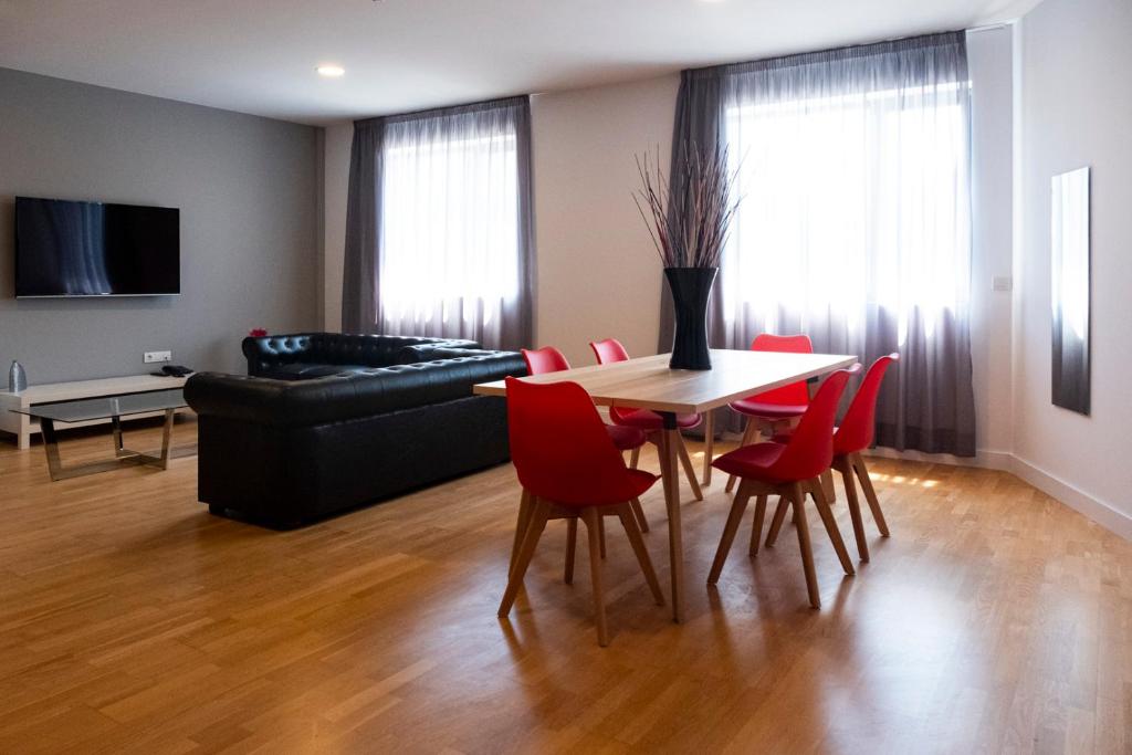 纳龙Spa Suites Odeón的客厅配有桌子和红色椅子