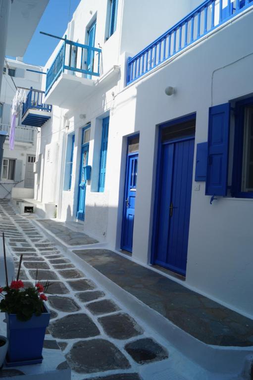 米克诺斯城凯马塔酒店的一排带蓝色门的白色建筑