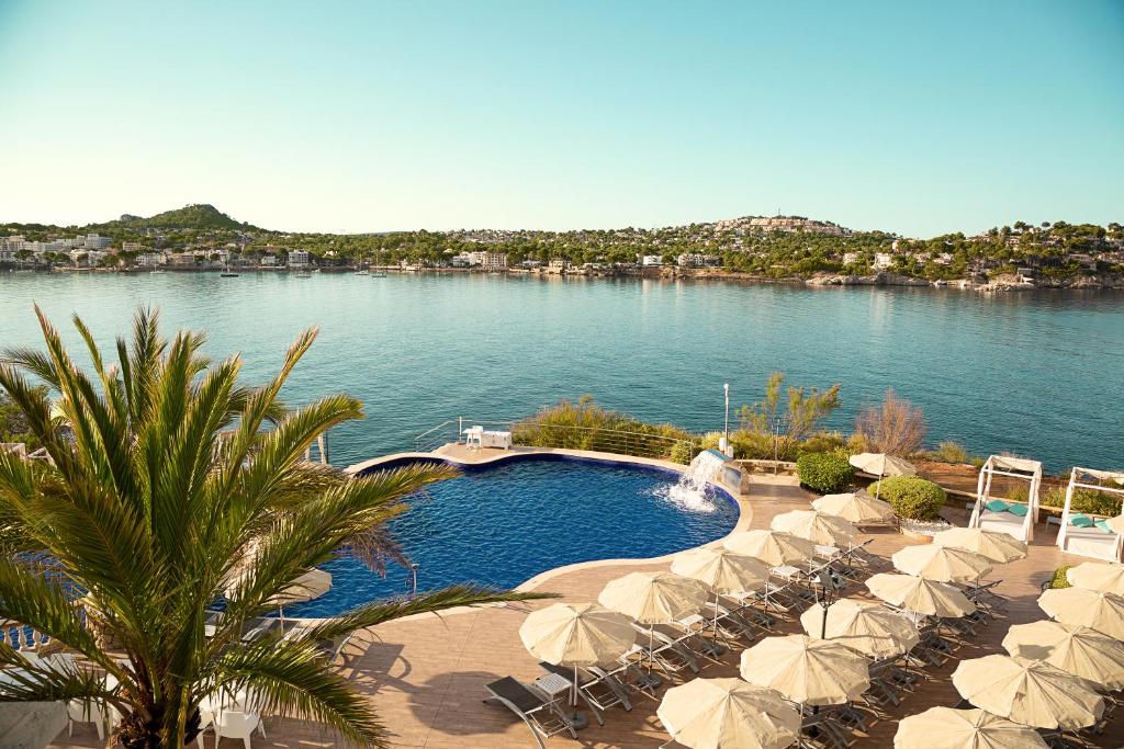 圣蓬萨Sentido Fido Punta del Mar Hotel & Spa - Adults Only的一个带遮阳伞和水体的游泳池