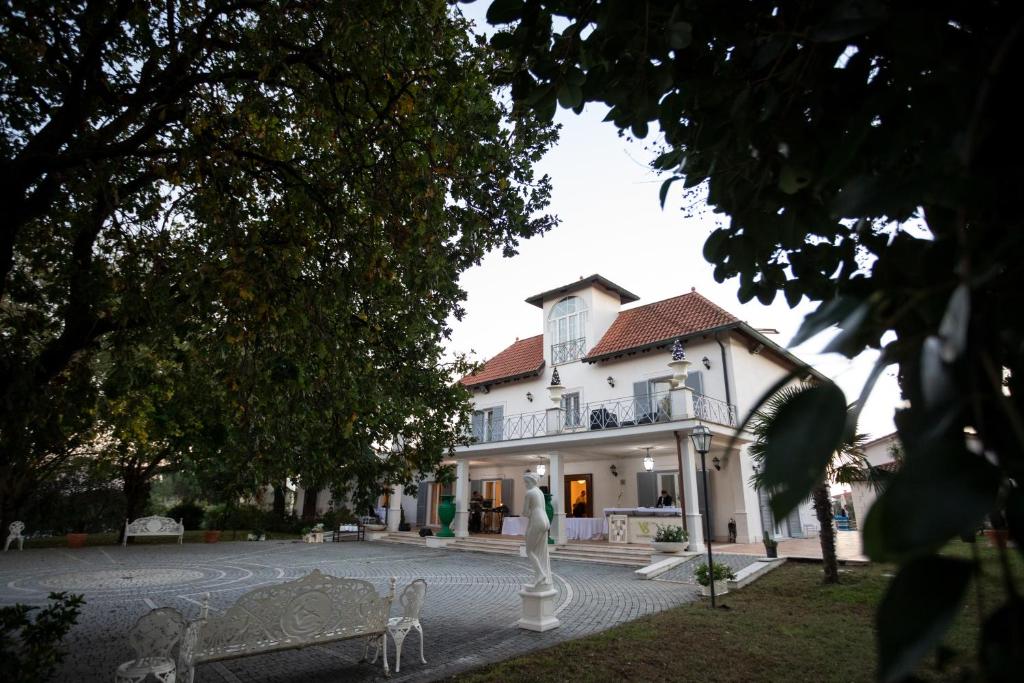 波梅齐亚斯特兰派利别墅的一座白色的大房子,前面有雕像