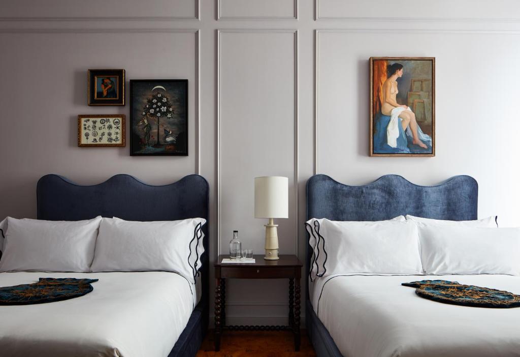 新奥尔良Maison de la Luz的一间卧室设有两张床,墙上挂着一幅画
