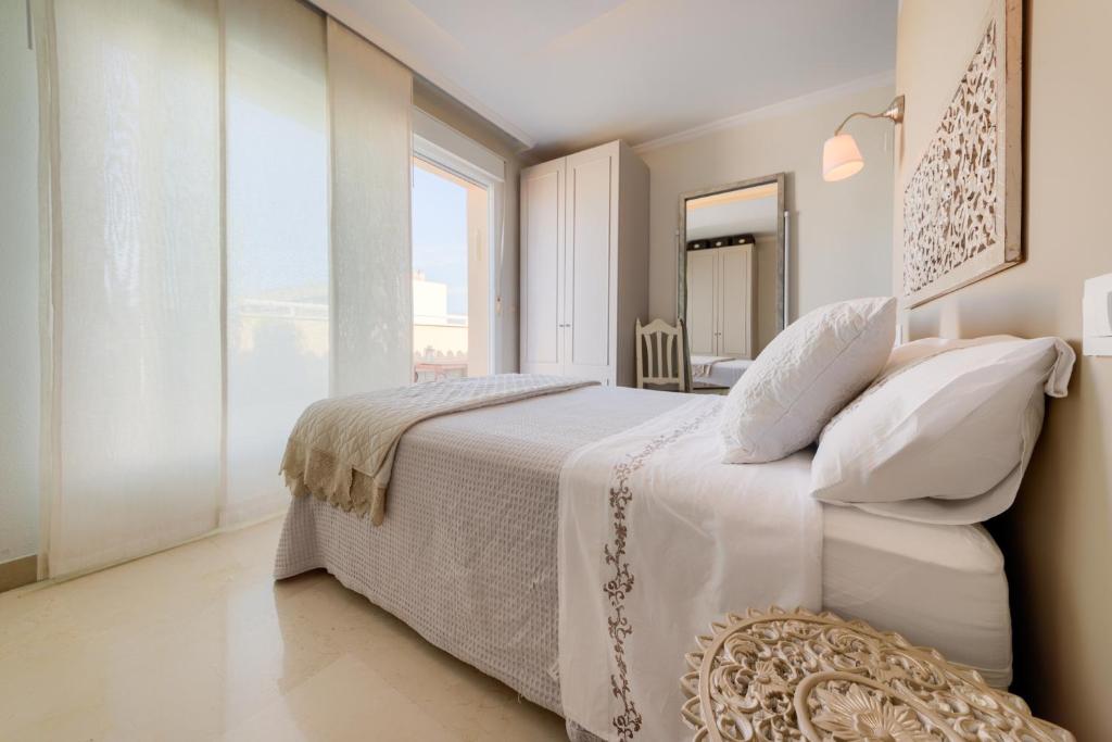 加的斯Ático parque Kotinoussa的白色的卧室设有一张大床和一个大窗户