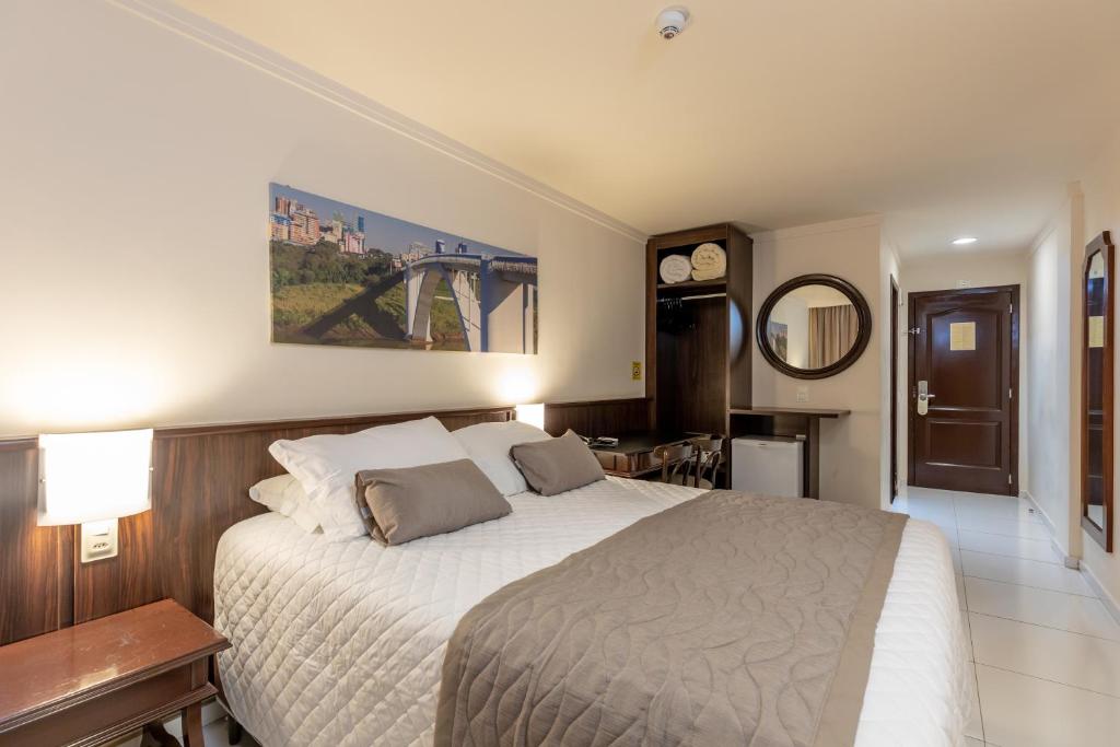 伊瓜苏伯格里酒店的一间卧室配有一张大床和镜子