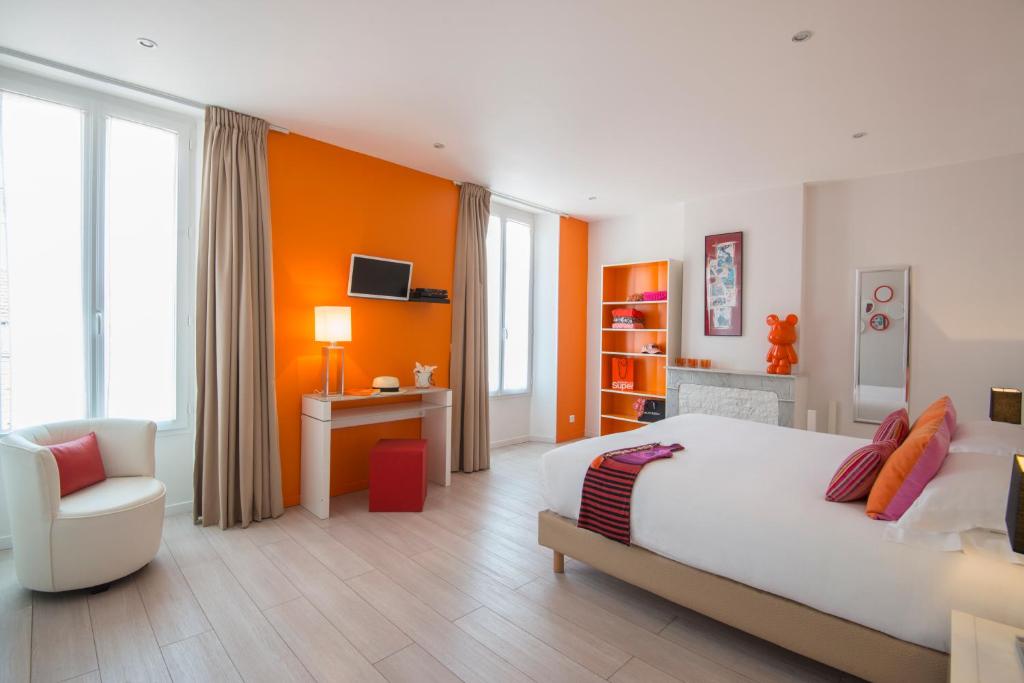 戛纳戛纳欧卡雷克鲁瓦塞特公寓式酒店的卧室配有一张白色大床和一把椅子