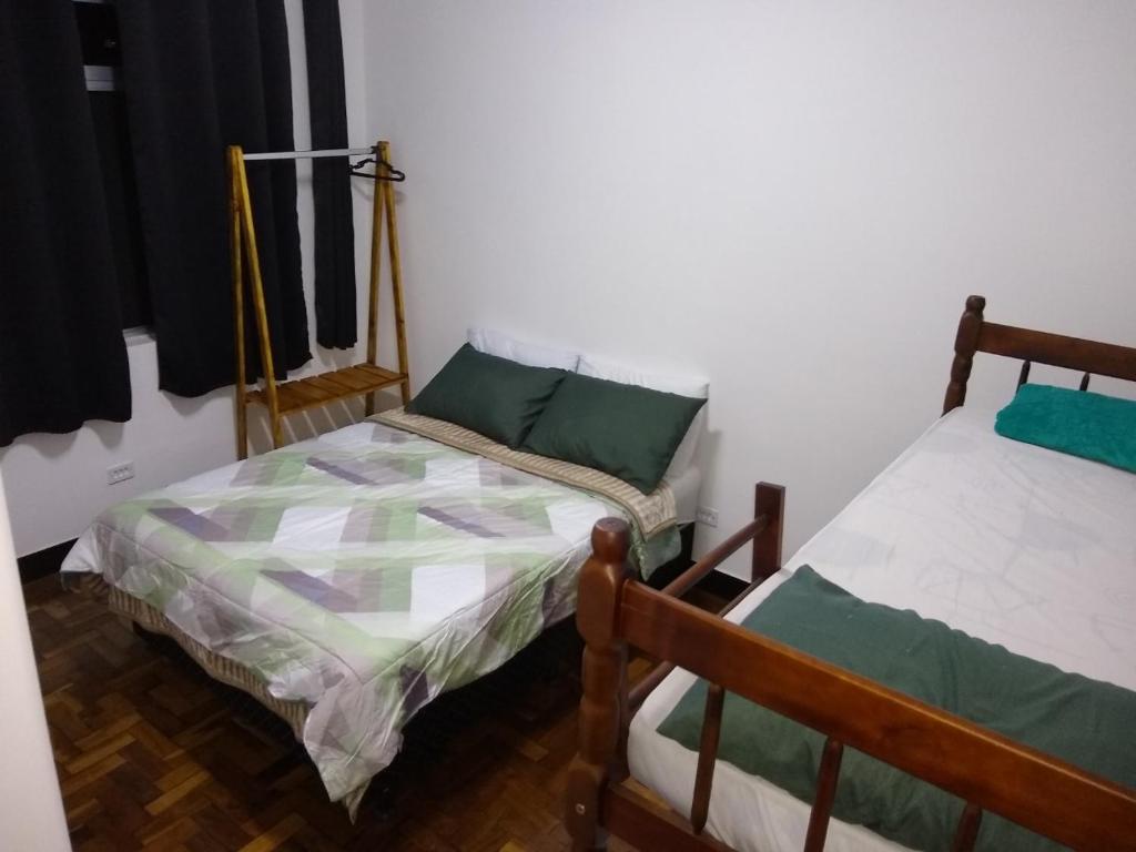 库里提巴Curitiba Central Hostel的一间客房内配有两张床的房间