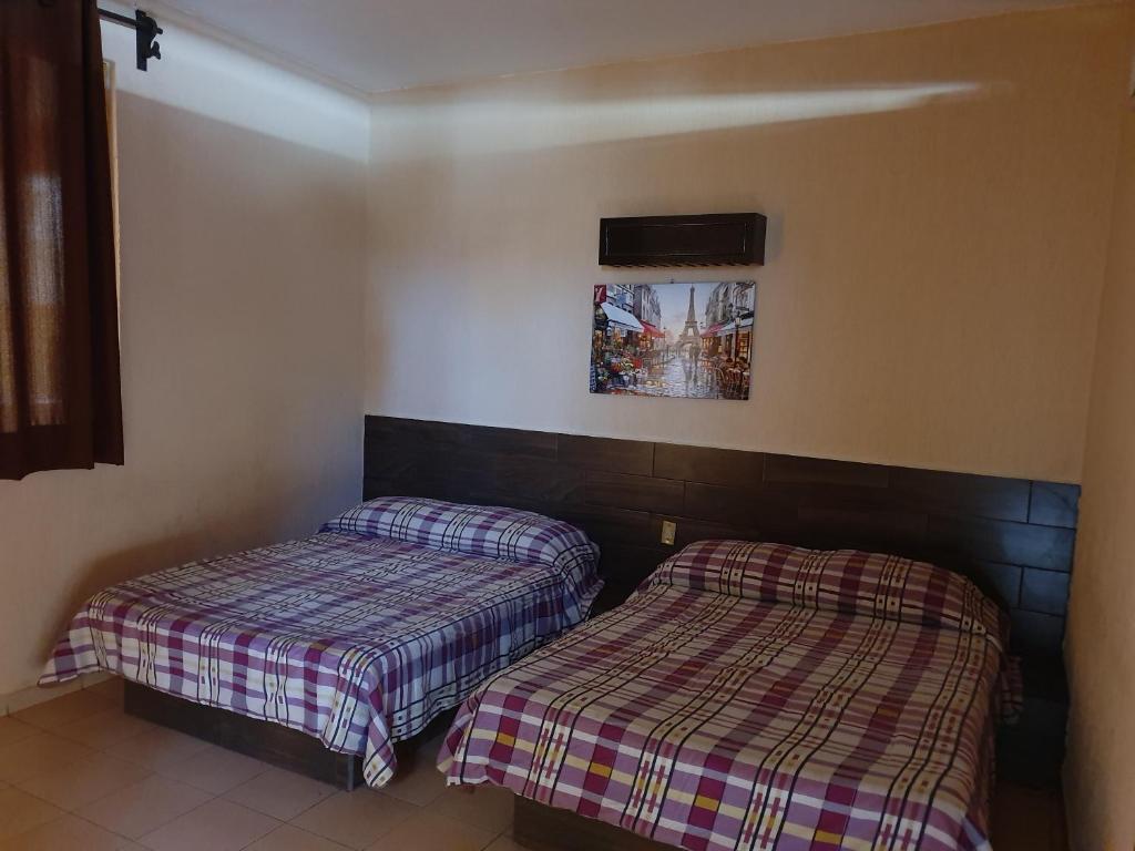 阿卡普尔科Costa Miramar的两张睡床彼此相邻,位于一个房间里