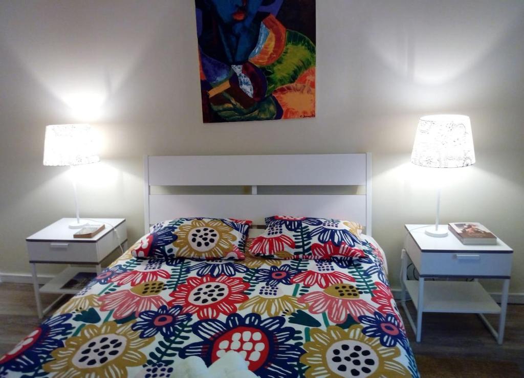 里斯本Famille au Cœur de Lisbonne的一间卧室配有一张床和两个带灯的床头柜