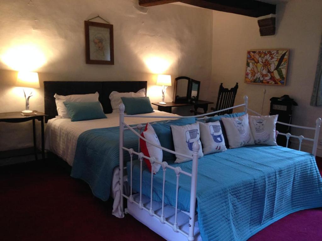 Matlock BankRiber Hall的一间卧室配有两张带蓝白色枕头的床