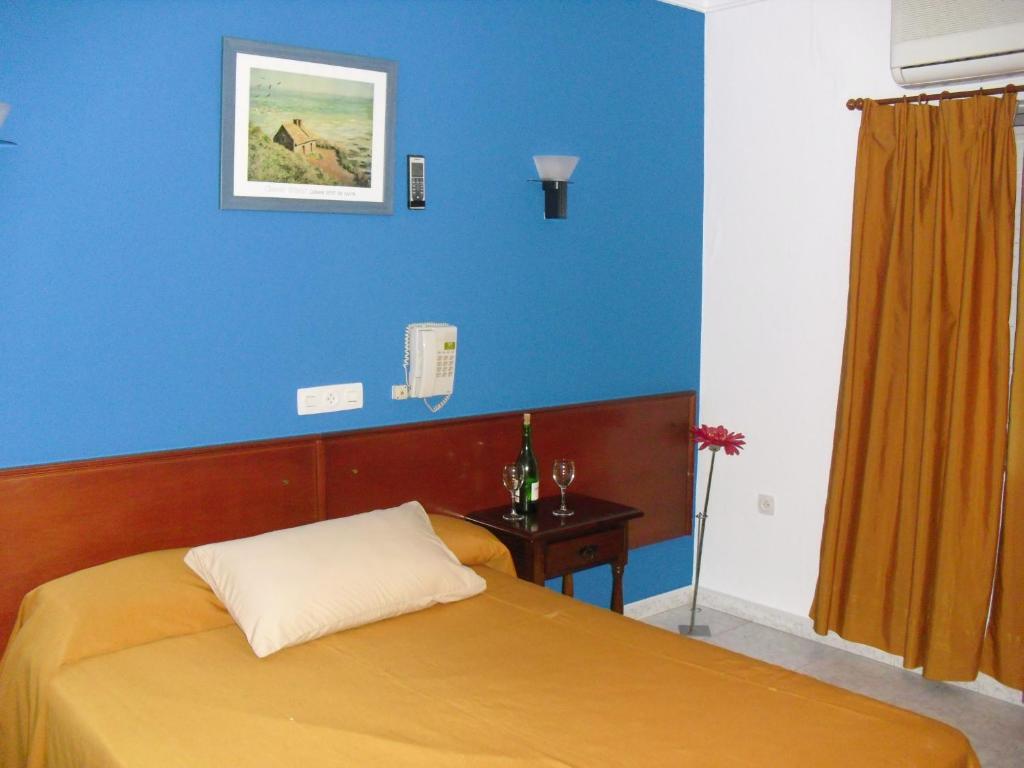 阿尔科斯-德拉弗龙特拉艾尔凡赛C＆R酒店的一间卧室配有一张蓝色墙壁的床
