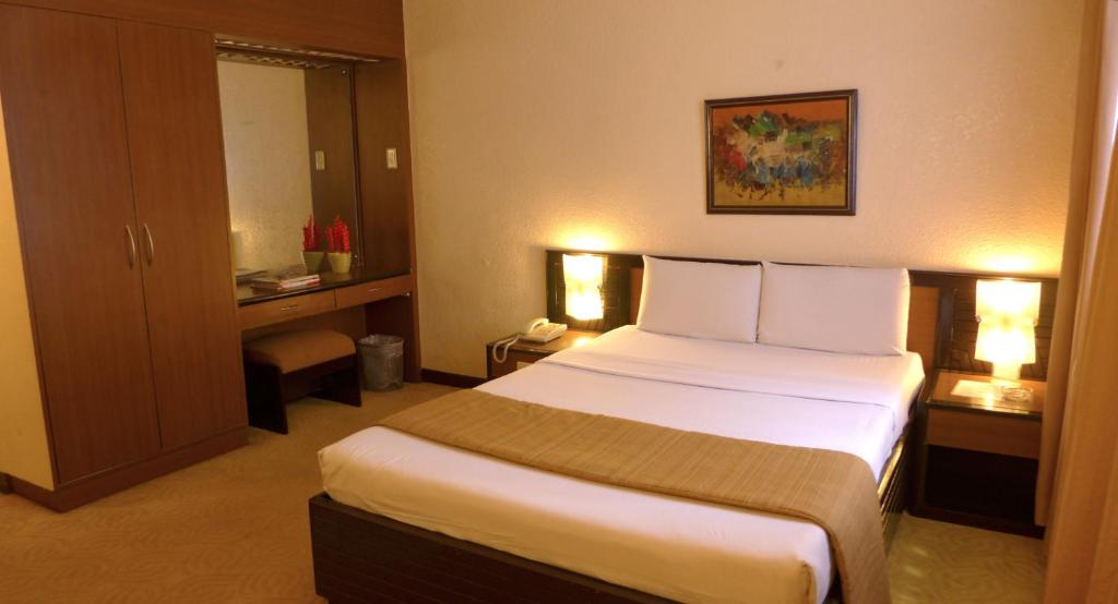 马尼拉罗斯曼酒店的一间位于酒店客房内的带大床的卧室