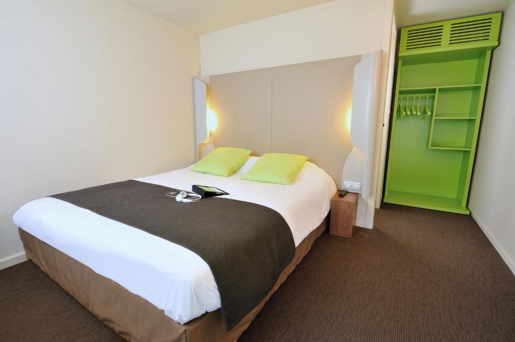 拉内斯泰尔洛里昂 - 兰内斯特钟楼酒店的一间卧室配有一张绿色的大白色床。