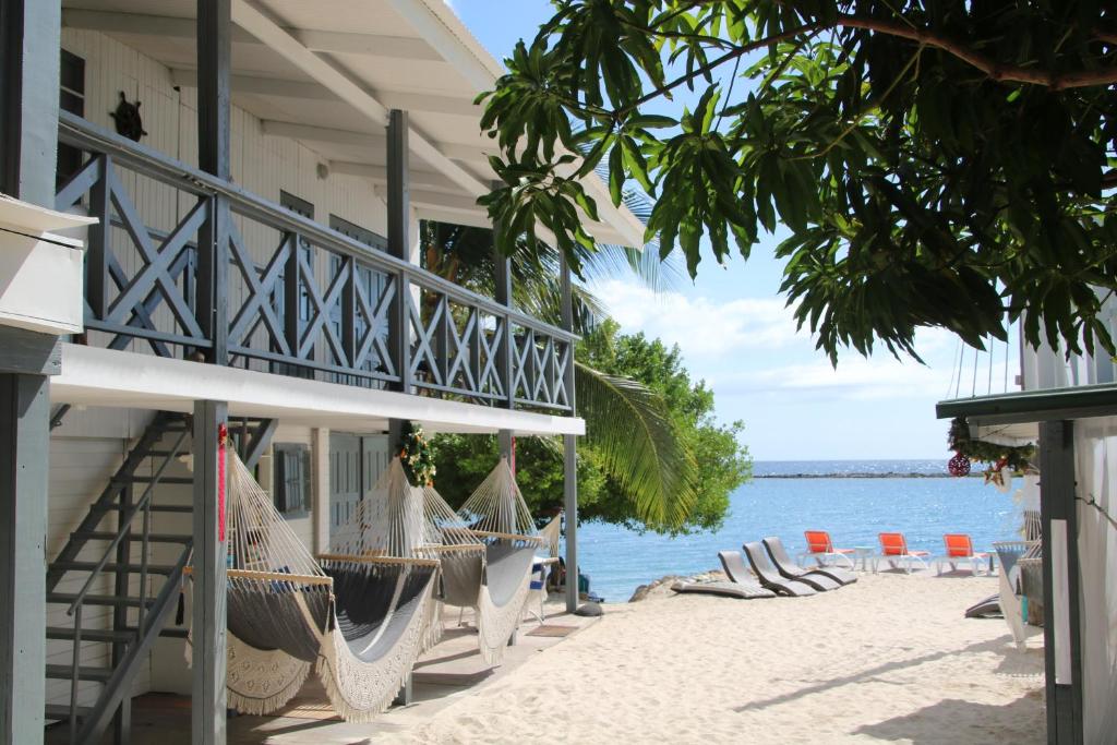 Savaneta珊瑚礁海滩酒店的海滩上带椅子和吊床的度假村