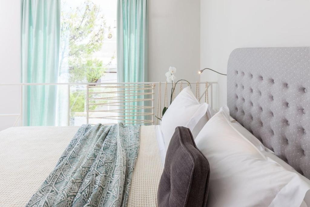 雅典纳弗斯卡酒店的卧室配有带白色枕头的床和窗户。