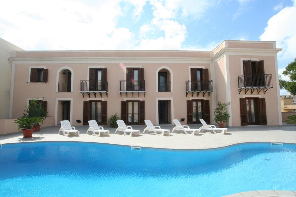 兰佩杜萨Moresco Resort的一座带游泳池、椅子和房屋的别墅
