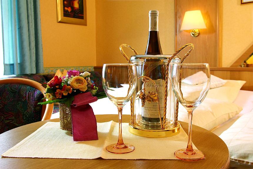 坎普-博尔恩霍芬Gästehaus Hotel Rheingraf的桌子上放有一瓶葡萄酒和两杯酒