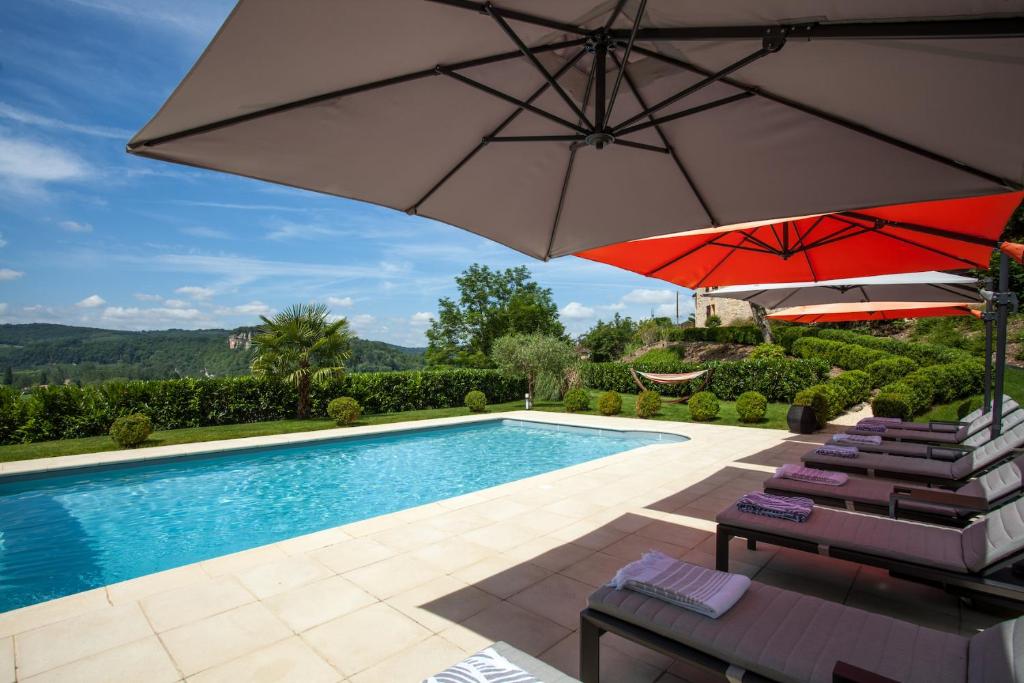 拉罗克加雅克莱萨德拉雅科麦森朵德斯塔德麦酒店的游泳池旁设有2把遮阳伞和椅子的游泳池