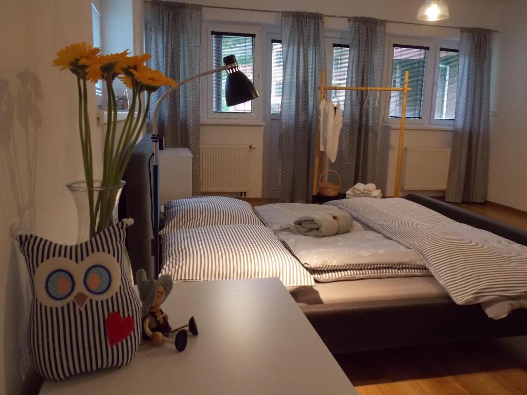 波普拉德Happy Guests apartment的一间卧室配有一张床,一个花瓶摆放在桌子上