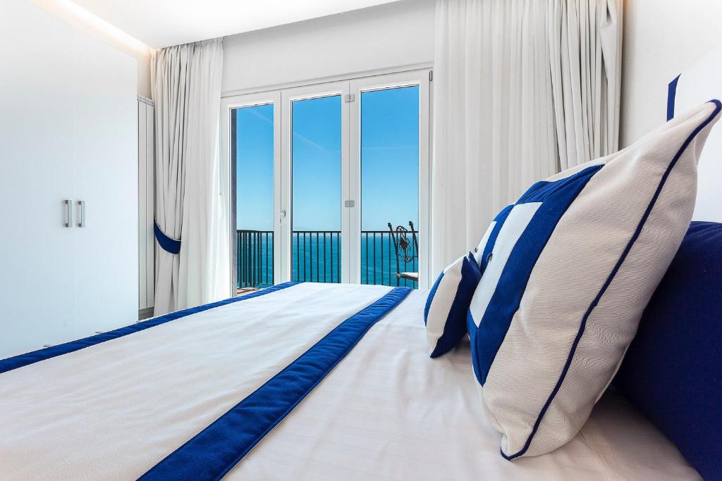 维耶特里布里斯托酒店的一间卧室配有一张带蓝白色枕头的大床