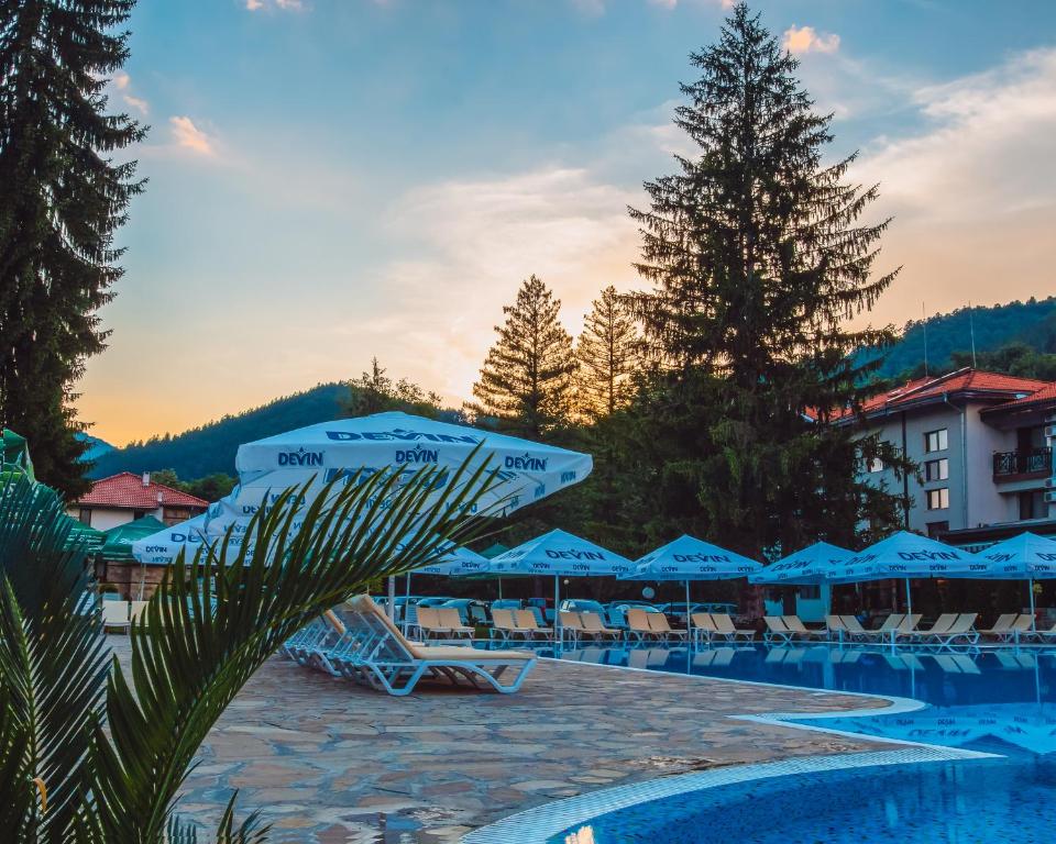 贝里奥苏姆奥斯特洛瓦假日酒店的一个带椅子和遮阳伞的游泳池的度假酒店