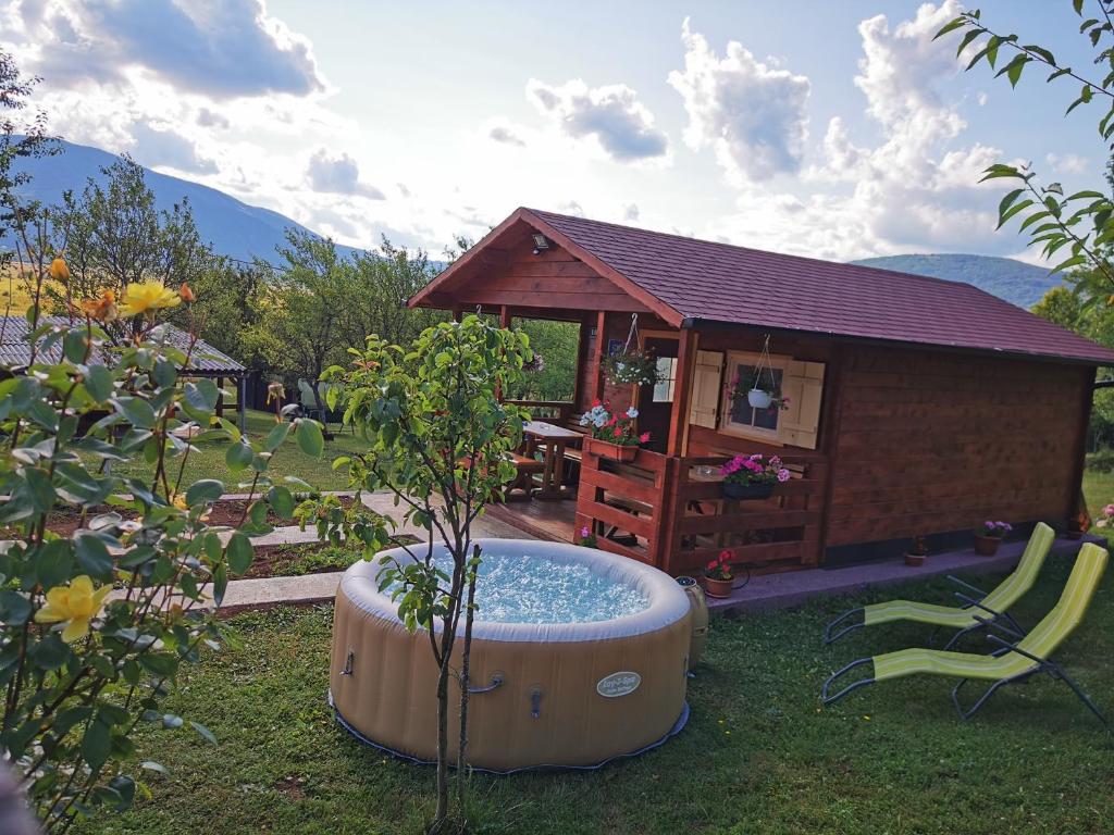 科雷尼察Cottage La Sierra with JACUZZI的小屋旁的草丛中的热水浴池