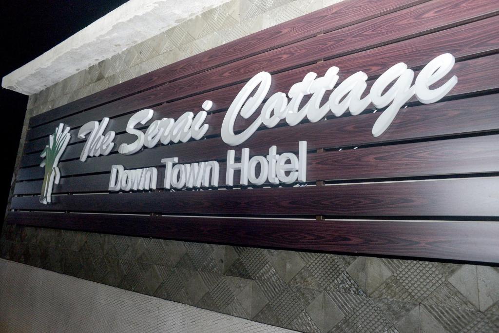 瓜拉丁加奴The Serai Cottage Downtown Hotel的桑塔克拉拉杜莫纳酒店标志