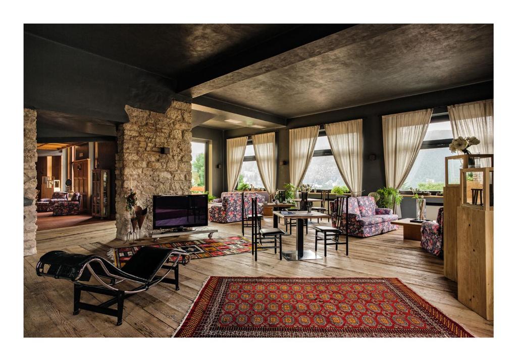 福尔加里亚意大利安蒂科阿尔贝哥斯黛拉酒店的客厅配有椅子、桌子和电视