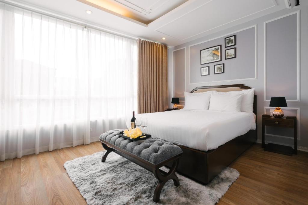河内La Palm Hotel的卧室配有床、椅子和窗户。