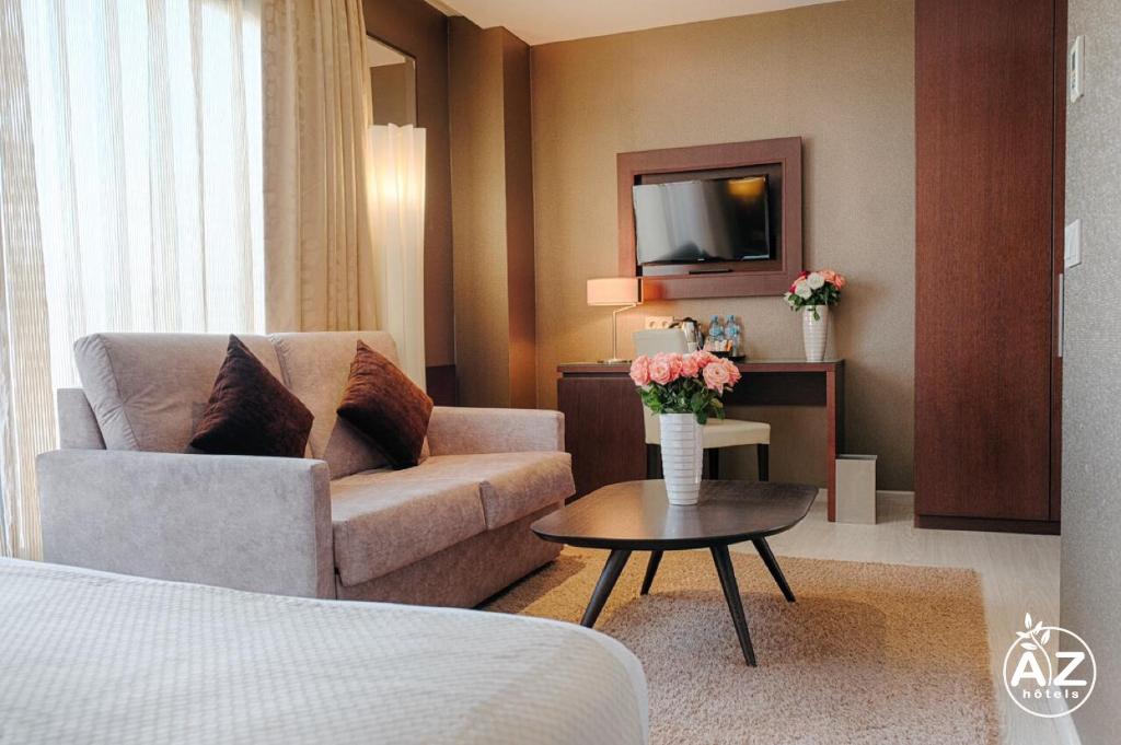 宰拉勒达AZ Hôtels Zeralda的酒店客房设有一张沙发和一张带电视的桌子。