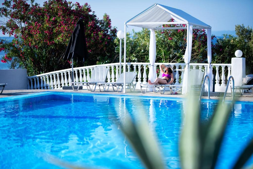 VatopediBianco Olympico Beach Resort-All Inclusive的坐在游泳池旁椅子上的一个小女孩