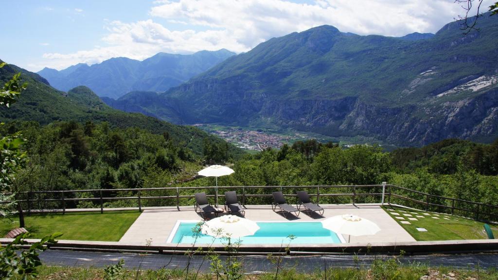 德利纳Maso Salim Relax Apartments的一个带椅子和遮阳伞的游泳池,享有山景