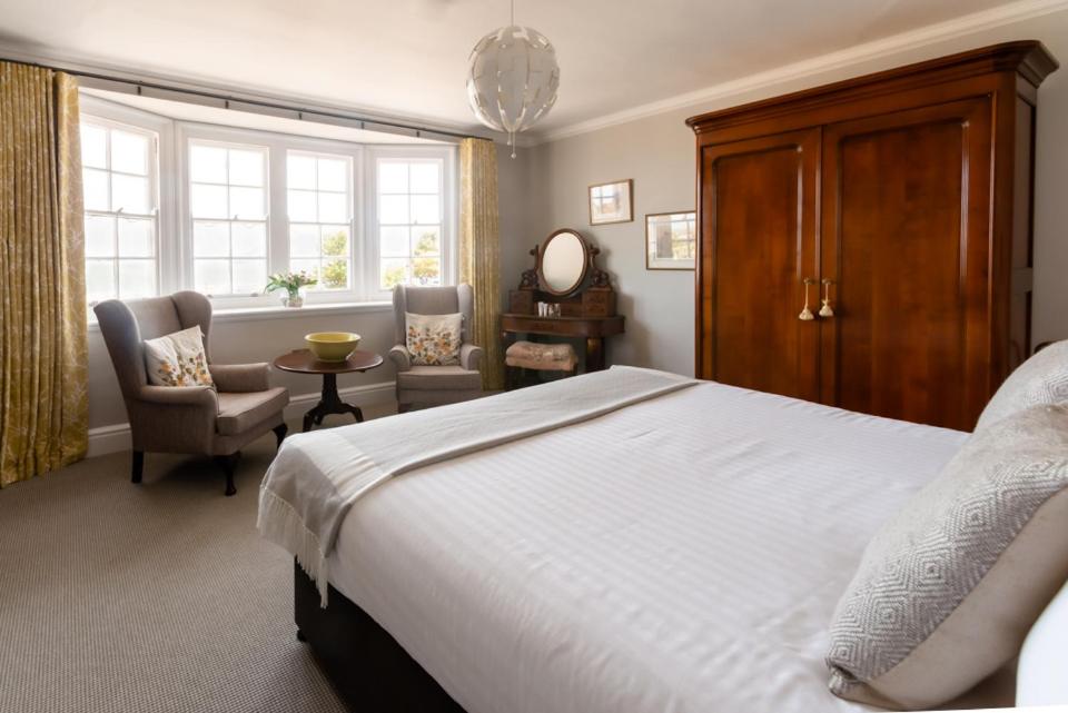 波洛克The Porlock Weir Hotel的卧室配有床、椅子和窗户。