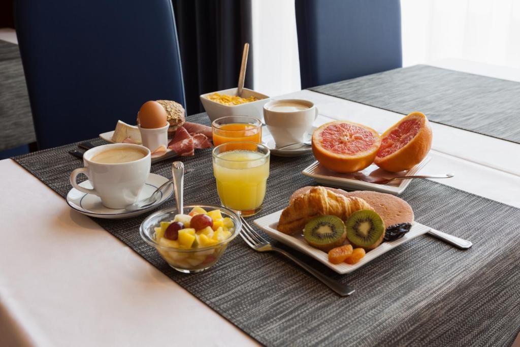 维金勒科吉特Kyriad Direct Rennes Ouest的早餐盘,包括早餐食品和桌上的饮料