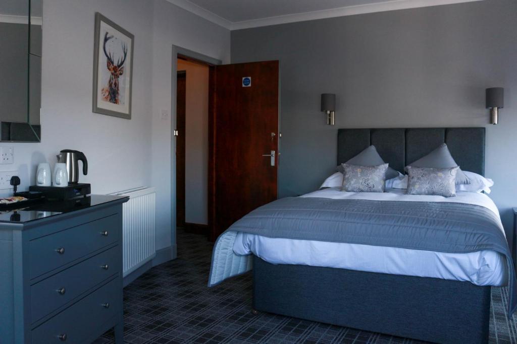 斯特兰拉尔The Royal Hotel的一间卧室配有一张大床和一个蓝色梳妆台