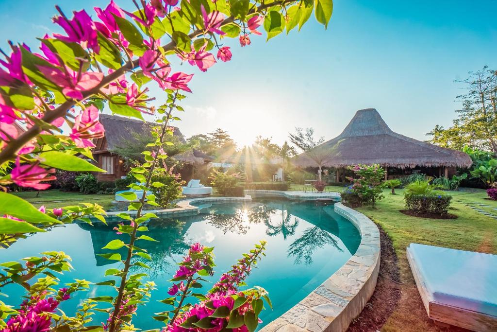 乌鲁瓦图Green Escape Eco Resort的鲜花花园内带游泳池的别墅