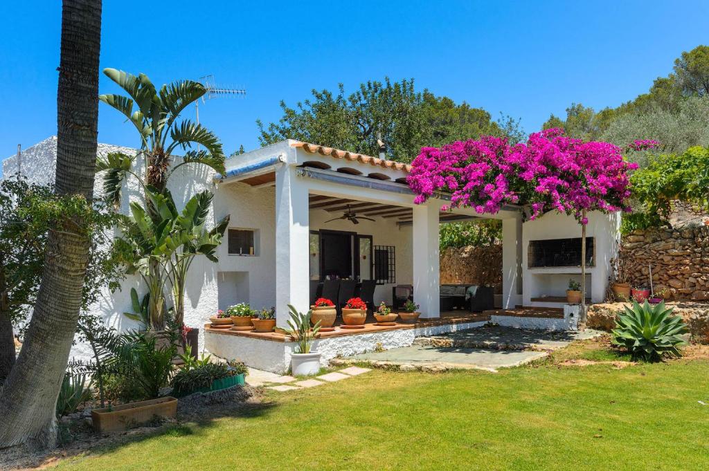 圣米克尔德巴兰Villa Benirrás的院子里有粉红色花的房子