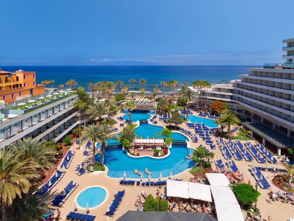 美洲海滩H10征服者酒店的享有带游泳池和海洋的度假村的空中景致