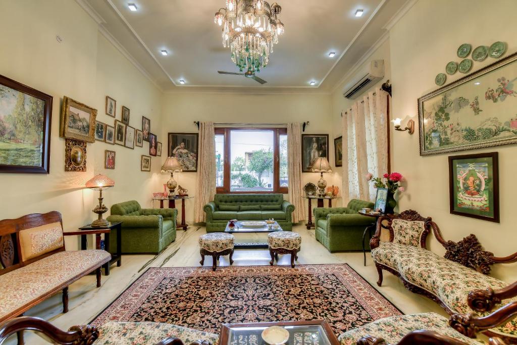 斋浦尔Dera Jaipur Homestay的客厅配有绿色家具和吊灯。