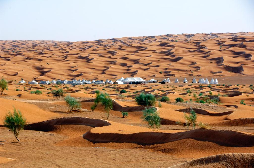 杜兹火星宿营地的沙漠,有沙丘和远处的房屋