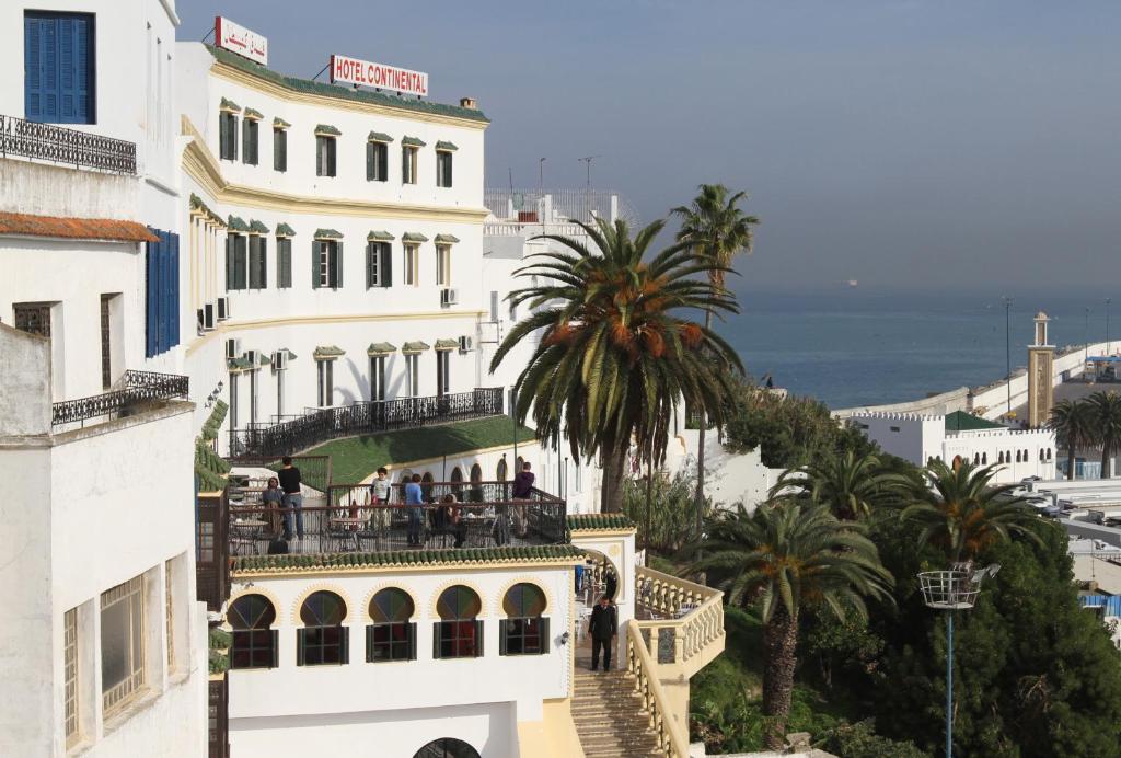 丹吉尔大陆酒店的一座白色的建筑,人们站在阳台上