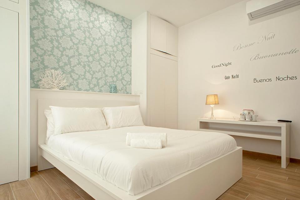 利沃诺My Home-Gorgona的白色的卧室配有白色的床和一张桌子