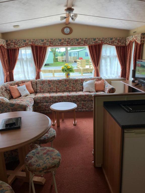 达农62 Glenfinart Caravan Park的客厅配有沙发和桌子