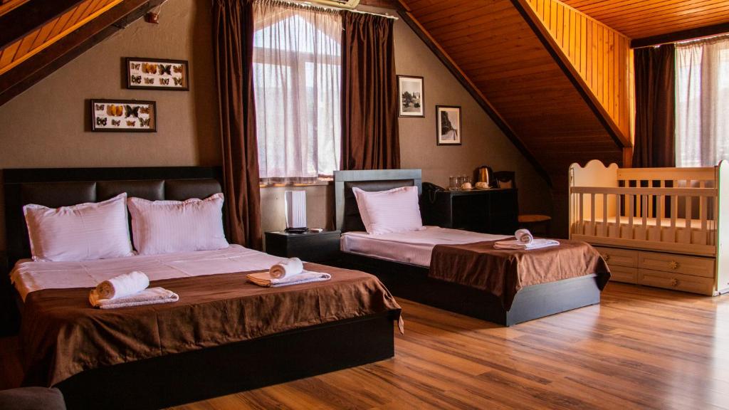 第比利斯纽麦泰基酒店的一间卧室配有两张床和一张婴儿床。