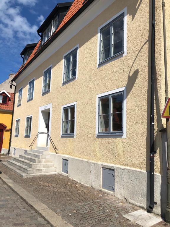 维斯比Apartments Strandgatan Visby的街道上拥有白色窗户和楼梯的建筑