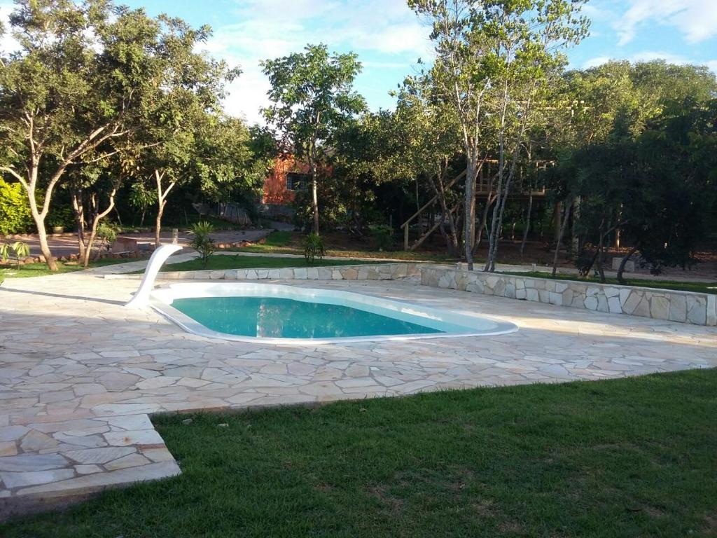 三玛丽亚镇Pousada e Restaurante Maria das Flores的庭院内的游泳池,设有石头庭院