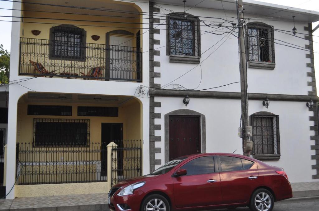 莱昂Cuartos Casa Blanca的停在房子前面的红色汽车