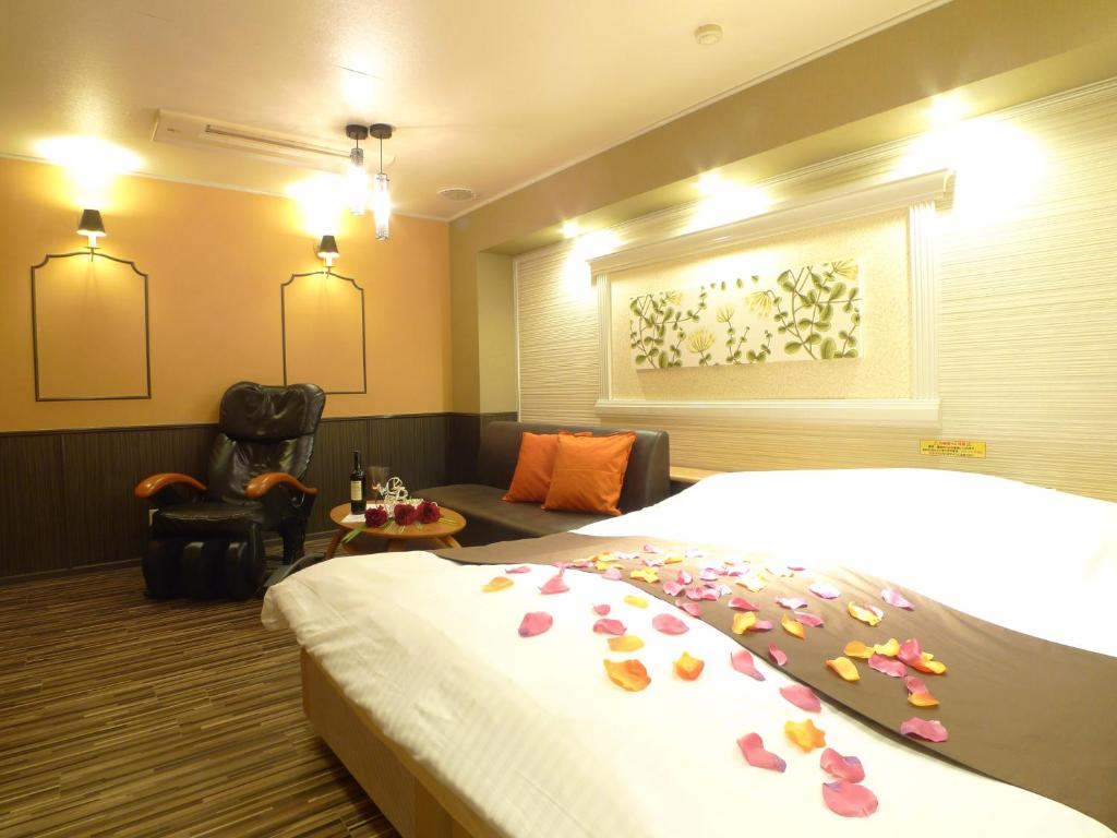 横滨Hotel GOLF Hodogaya (Adult Only)的一间酒店客房,床上摆放着鲜花