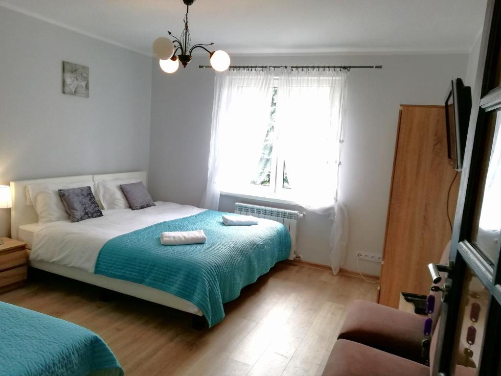 什奇特诺Leśny Apartament的一间卧室设有一张床和一个窗口