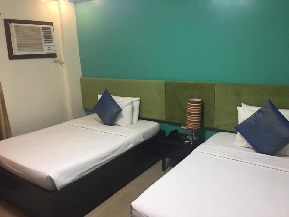 长滩岛长滩岛雷西登西亚酒店的客房配有两张带蓝白色枕头的床。